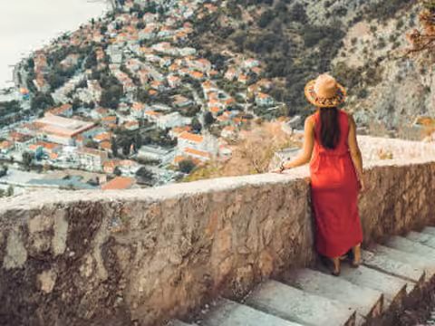 A traveller looking out over the terracotta roofs of an Adriatic old town