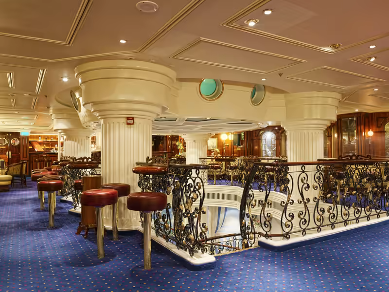 The piano bar on Royal Clipper with wrought iron balustrades and red bar stools