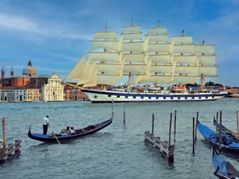 Royal Clipper under full sail off Venice, with a gondola in the foreground